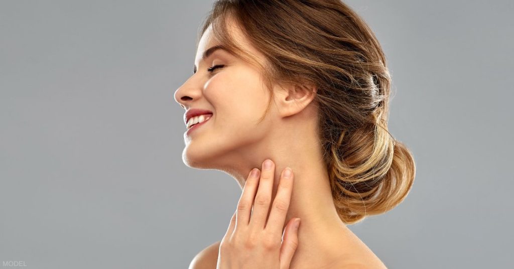 Woman with great jawline touching her neck (model)