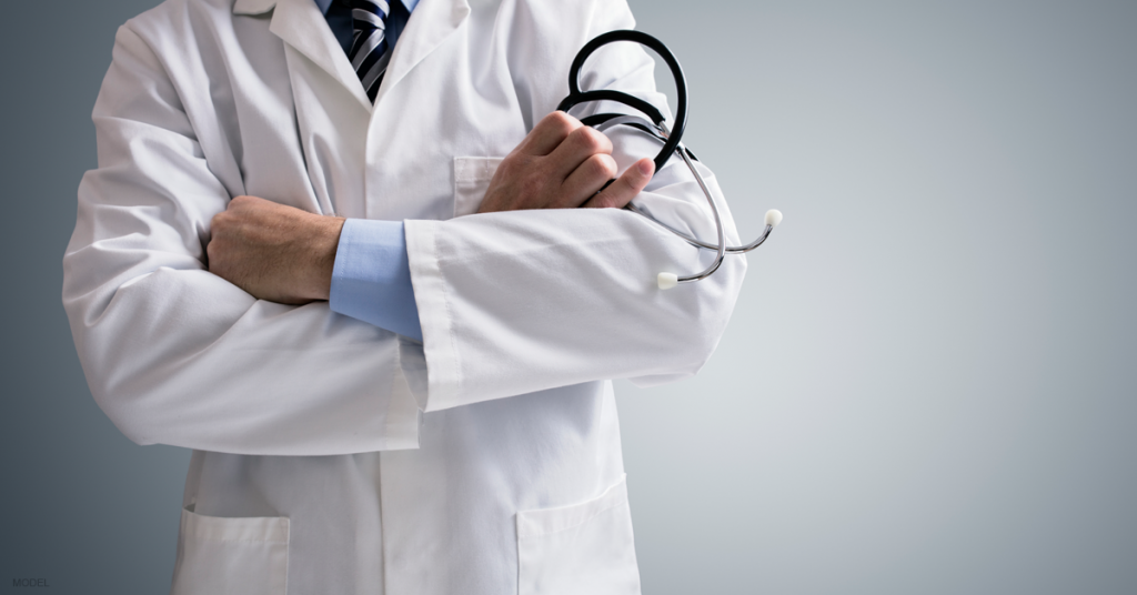 A Scottsdale surgeon crosses his arms while holding a stethoscope.