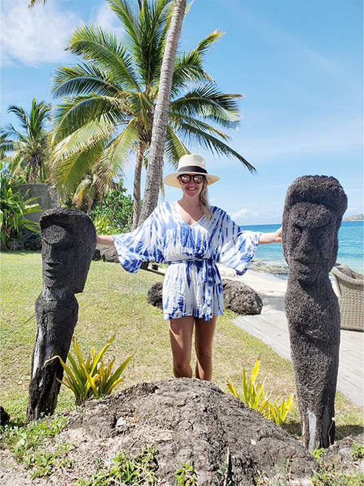 Ashley standing next to carved statues