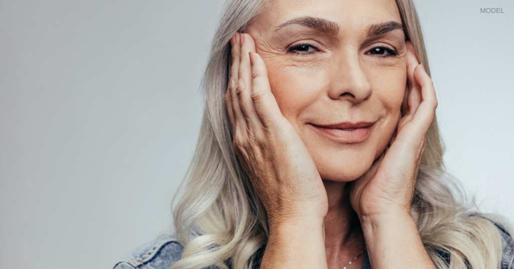 Woman touching face and smiling after eyelid surgery in scottsdale, az