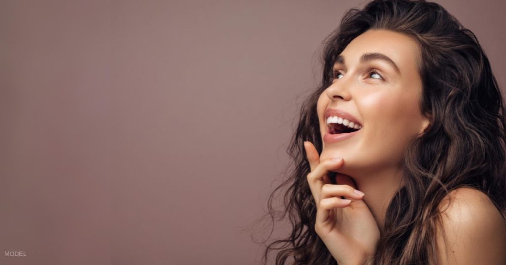 A beautiful woman is looking up while laughing. (MODEL)