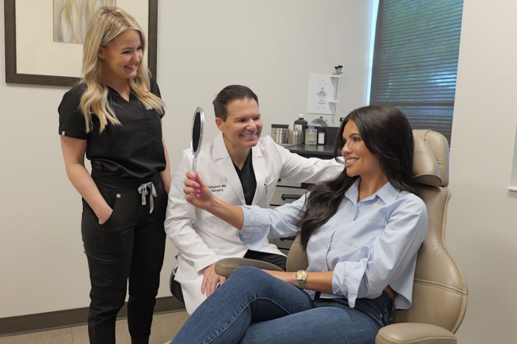 Dr. Hobgood and Ashley looking at a woman's face